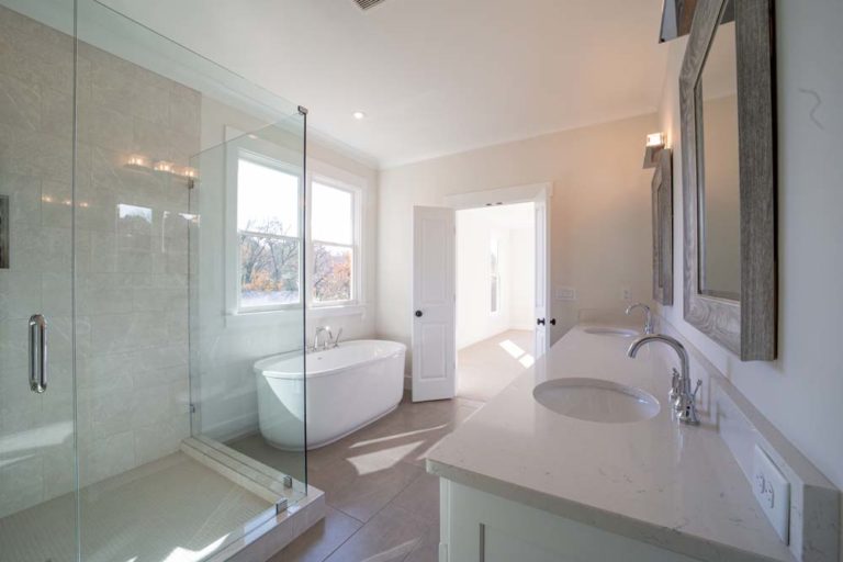 Bathroom with his and hers sinks, large tiled shower, stand-alone tub, large window